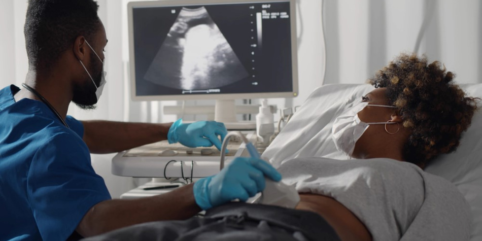 A pregnant woman watches the ultrasound screen as her OB performs an
    abdominal ultrasound.